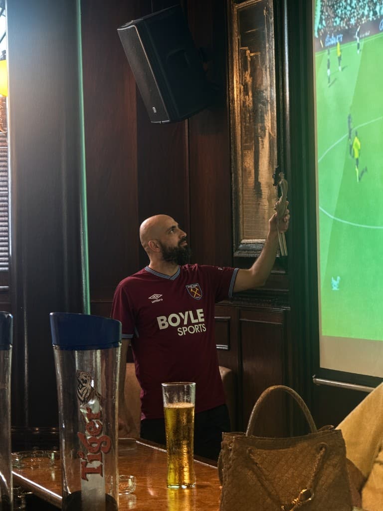Melo Doumani at the back of a Dubai pub, watching a match on the big screen